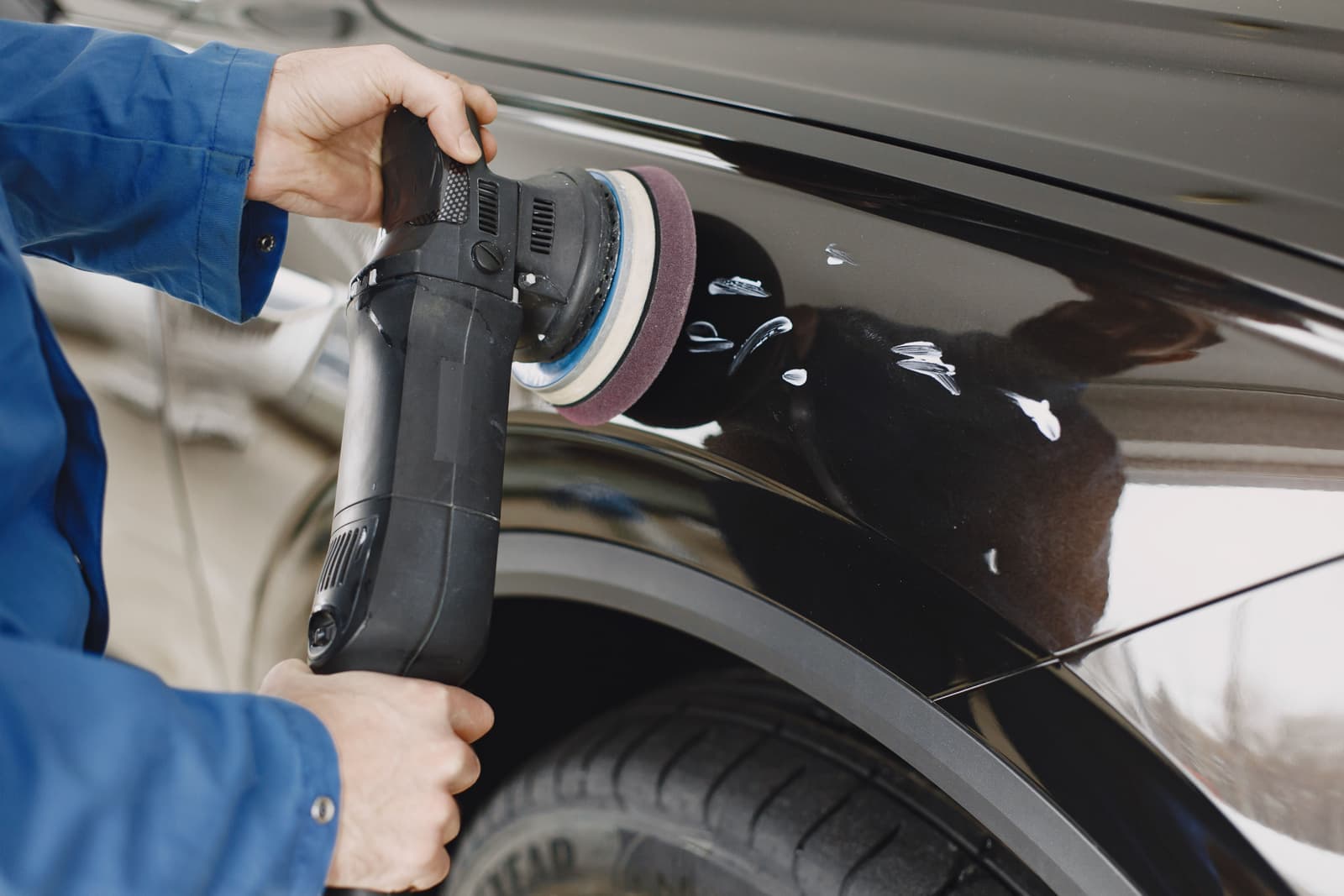 A dual action polisher being worked across a car panel